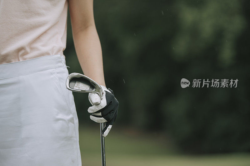 close up asian chinese female golfer's hamd on golf club